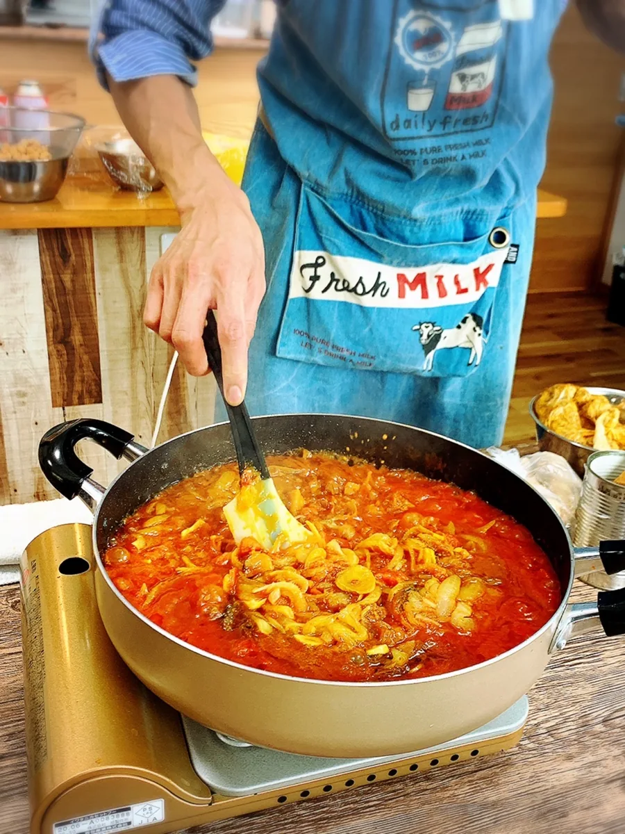 鍋でソースを試作しながら味を調整している様子